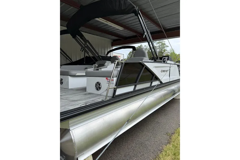 Slide: The Image of 2026 Crest Caribbean 250 SLRC pontoon boat under a metal canopy. - 2