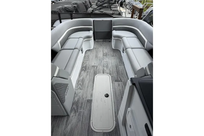 Slide: The Image of 2026 Crest Caribbean 250 SLRC boat interior with sleek gray seating and wood-style flooring. - 6