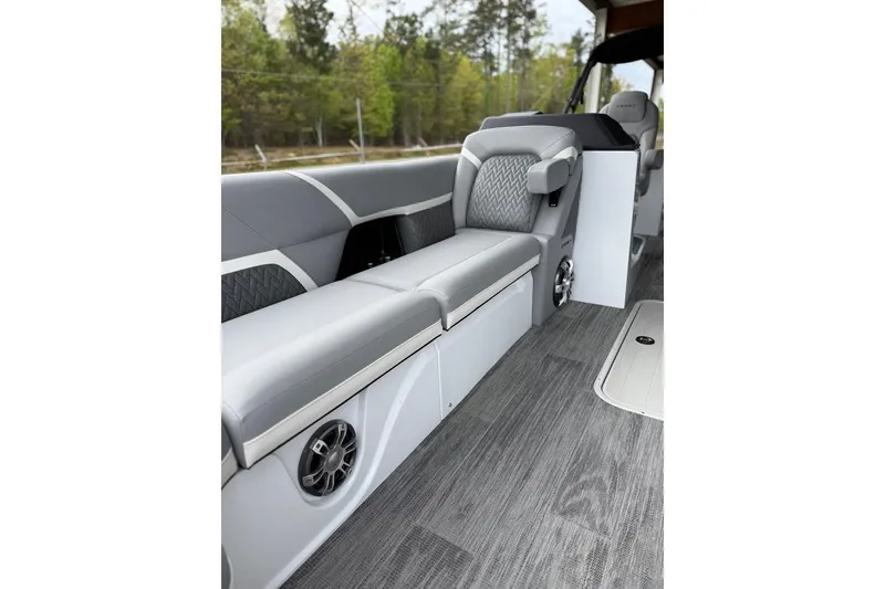 Slide: The Image of 2026 Crest Caribbean 250 SLRC boat interior with gray seating and wood-style flooring. - 8
