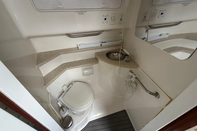 Slide: The Image of 2008 Fountain 33 Sportfish Cruiser bathroom with toilet, sink, and mirror. - 13