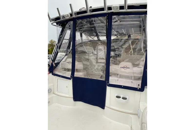 Slide: The Image of 2008 Fountain 33 Sportfish Cruiser with blue canvas enclosure and visible interior seating. - 15