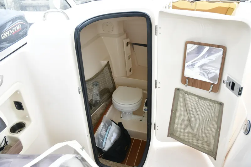 Slide: The Image of 2013 Grady-White Freedom 275 boat interior with compact marine toilet and storage. - 10