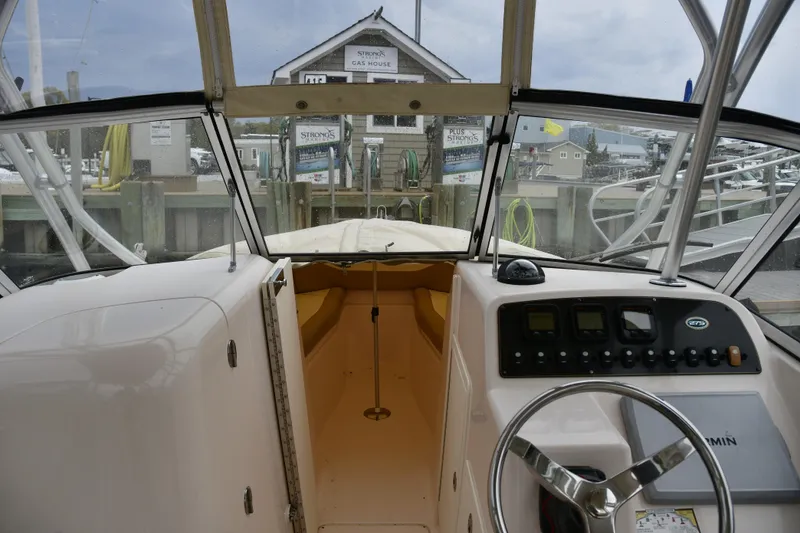 Slide: The Image of 2013 Grady-White Freedom 275 boat cockpit with steering wheel and control panel. - 11