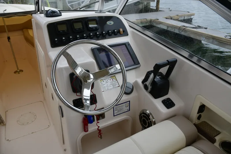 Slide: The Image of 2013 Grady-White Freedom 275 boat cockpit with steering wheel and control panel. - 6