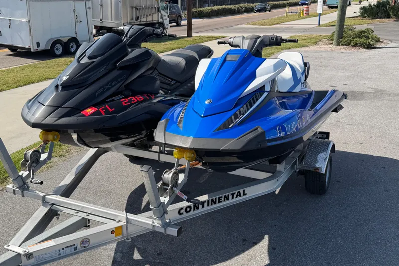 Slide: The Image of Two 2024 Yamaha WaveRunner FX SVHO jet skis on a trailer, parked outdoors. - 13