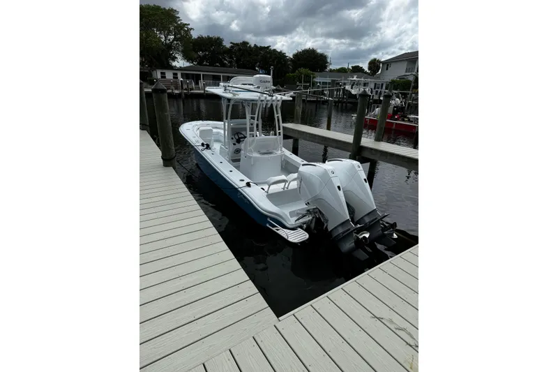 Slide: The Image of 2024 Yellowfin 26 Hybrid boat docked, featuring dual outboard engines. - 1