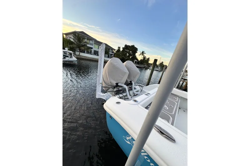 Slide: The Image of 2024 Yellowfin 26 Hybrid boat docked on a serene waterfront at sunset. - 4