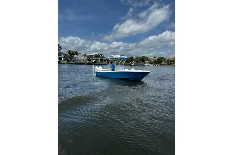 Slide: The Image of 2024 Yellowfin 26 Hybrid boat on calm water under a partly cloudy sky. - 5