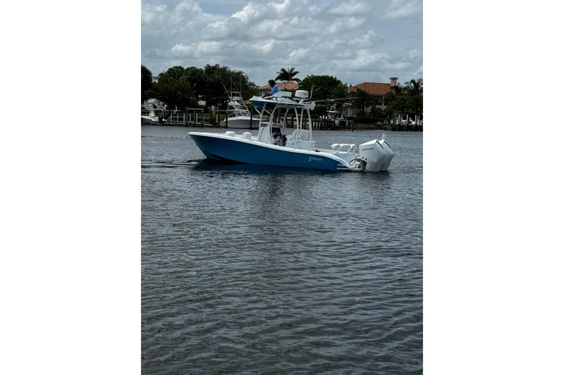 Slide: The Image of 2024 Yellowfin 26 Hybrid boat cruising on a calm waterway under a cloudy sky. - 7