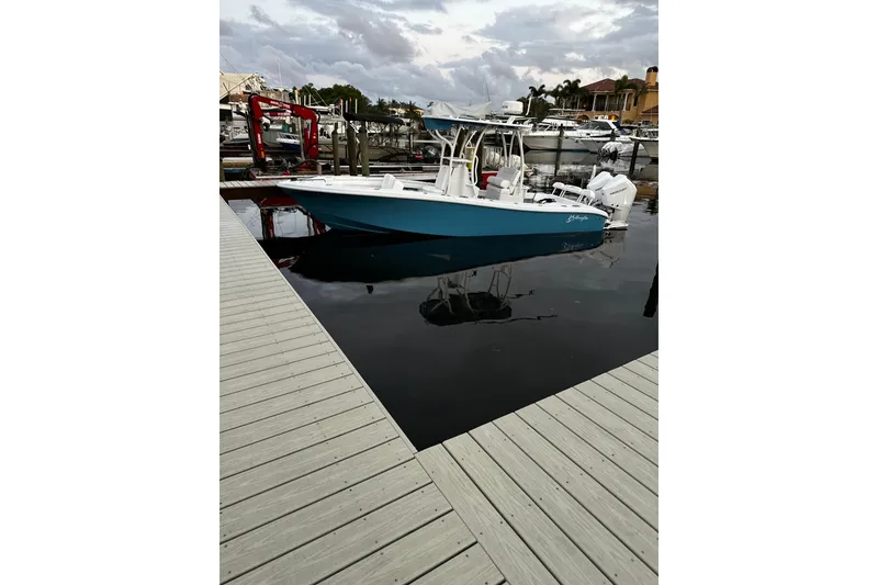 Slide: The Image of 2024 Yellowfin 26 Hybrid boat docked at marina under cloudy sky. - 9