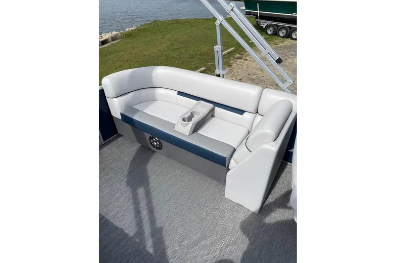 Slide: The Image of 2022 Godfrey Sweetwater 2286 SBX boat seating with cup holders, near water and grass. - 10