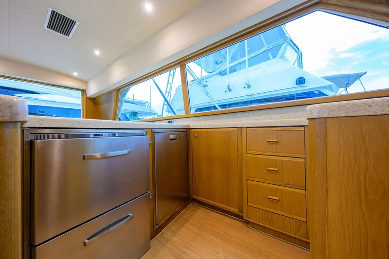 Slide: The Image of Interior of a 1998 Bertram 54 yacht kitchen with wooden cabinets and stainless steel appliances. - 10