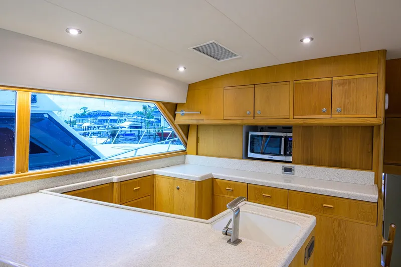 Slide: The Image of Luxurious kitchen interior of a 1998 Bertram 54 yacht with wooden cabinets and modern appliances. - 12