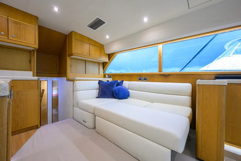 Slide: The Image of Luxurious interior of a 1998 Bertram 54 yacht with white seating and wooden cabinetry. - 16