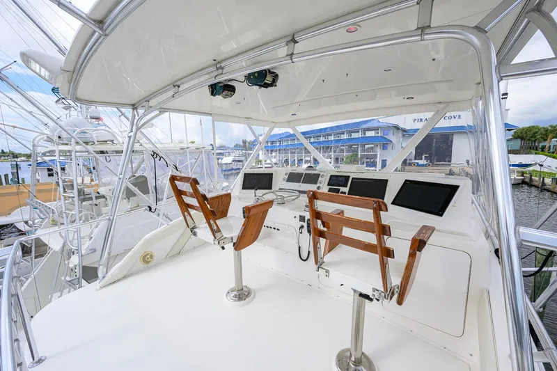 Slide: The Image of Cockpit of a 1998 Bertram 54 yacht with wooden chairs and navigation equipment. - 19