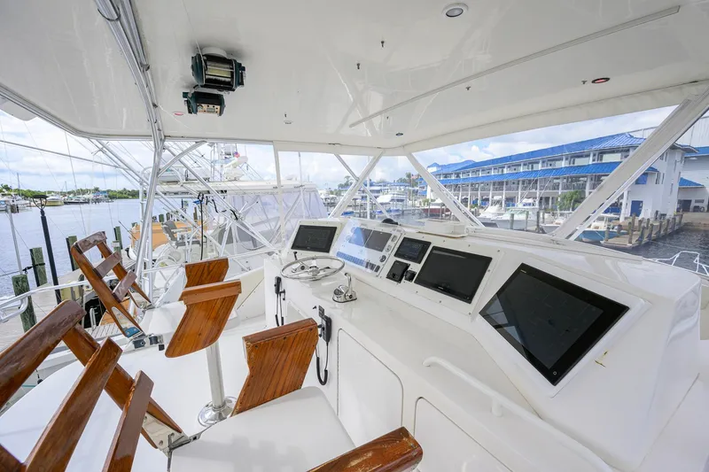Slide: The Image of Cockpit of a 1998 Bertram 54 yacht with wooden chairs and navigation equipment. - 20