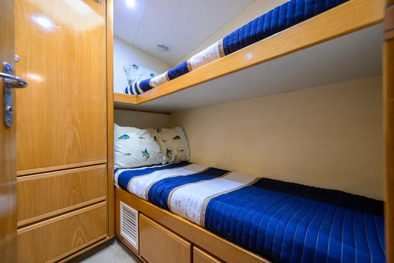 Slide: The Image of Bunk beds in a 1998 Bertram 54 yacht cabin with wooden cabinetry. - 24