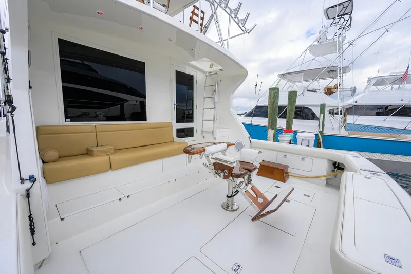 Slide: The Image of 1998 Bertram 54 yacht deck with seating and fishing chair at marina. - 3