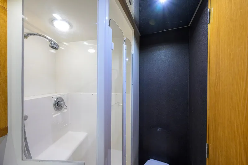 Slide: The Image of Shower area in a 1998 Bertram 54 yacht, featuring modern fixtures and lighting. - 30