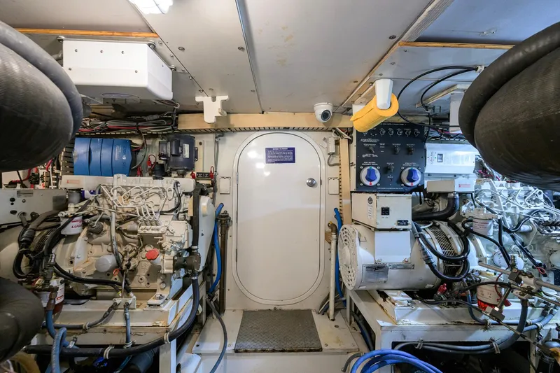 Slide: The Image of Engine room of a 1998 Bertram 54 yacht, featuring machinery and control panels. - 32