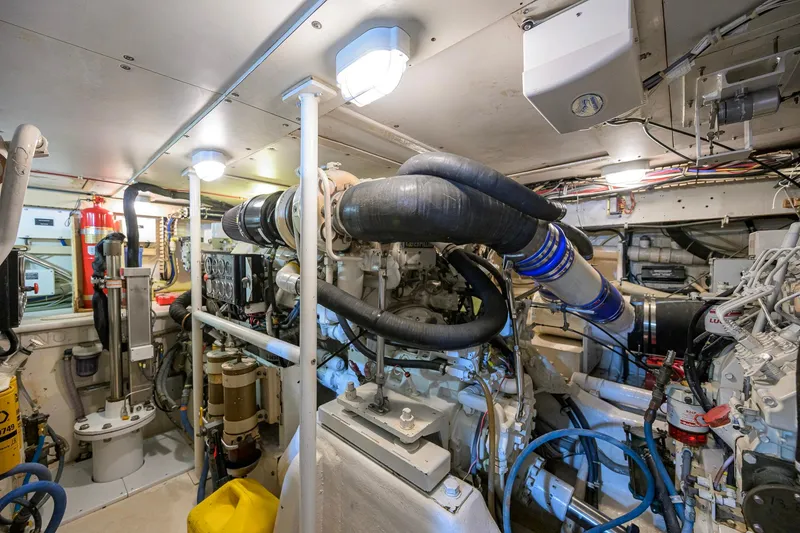 Slide: The Image of Engine room of a 1998 Bertram 54 yacht, showcasing complex machinery and piping. - 34