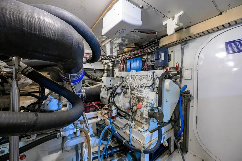 Slide: The Image of Engine room of a 1998 Bertram 54 yacht, showcasing complex machinery and wiring. - 35