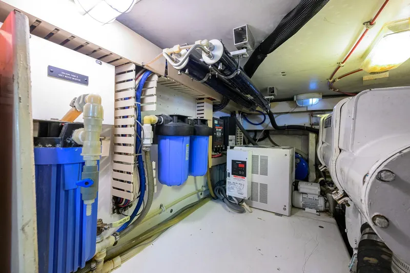 Slide: The Image of Engine room of a 1998 Bertram 54 yacht, featuring water filtration and electrical systems. - 39