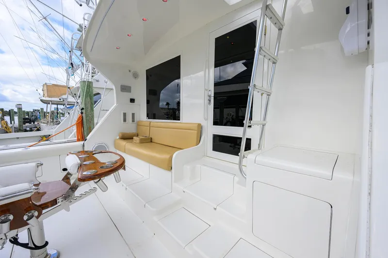 Slide: The Image of 1998 Bertram 54 yacht deck with seating, ladder, and fishing equipment. - 4