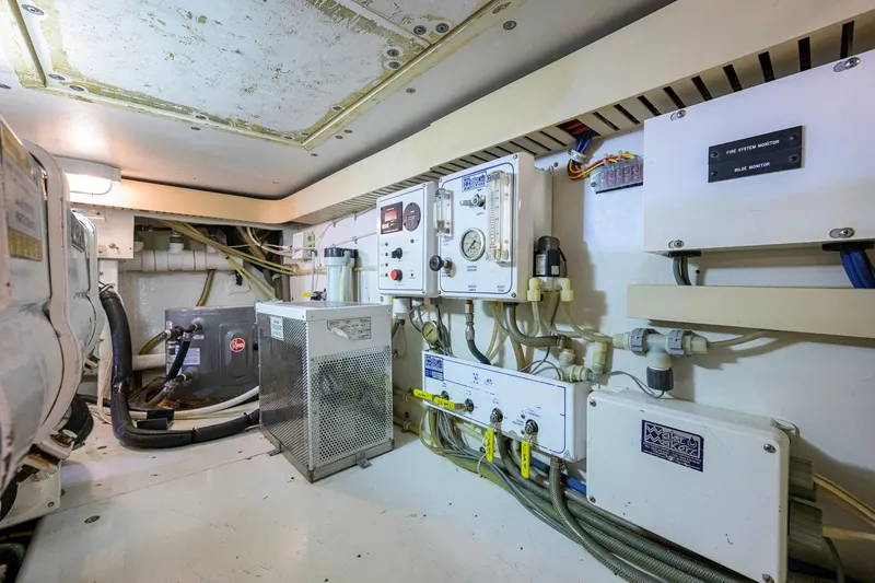 Slide: The Image of Engine room of a 1998 Bertram 54 yacht, featuring control panels and wiring. - 40