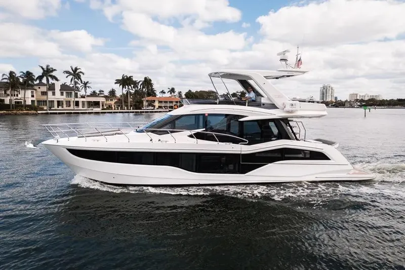 The Image of 2024 Galeon 500 Fly yacht cruising on a scenic waterway with palm trees. - 0