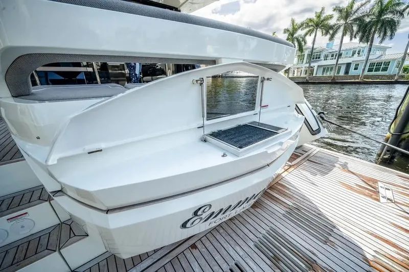 Slide: The Image of 2024 Galeon 500 Fly yacht with open grill on deck, docked by waterfront homes. - 10