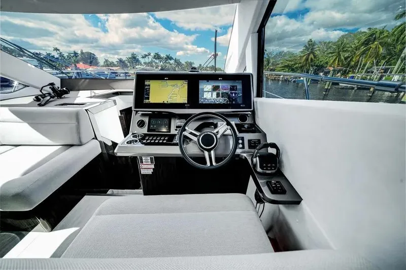 Slide: The Image of 2024 Galeon 500 Fly yacht cockpit with modern navigation system and scenic waterfront view. - 33