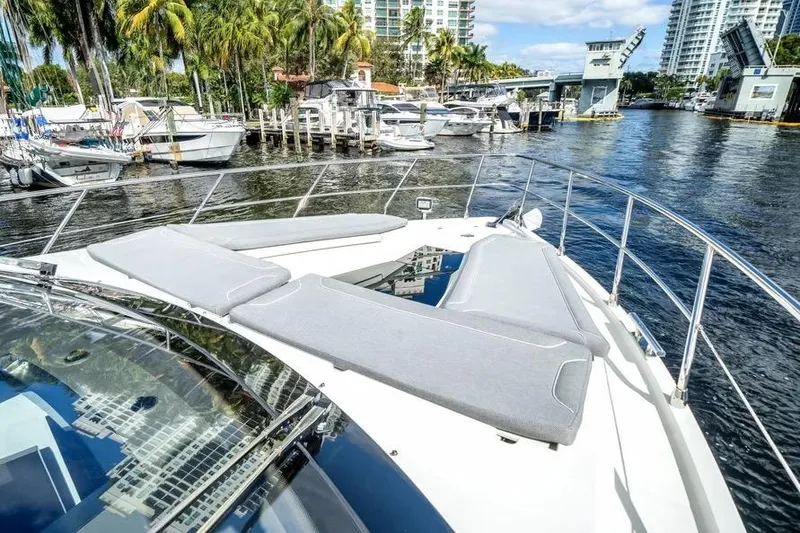 Slide: The Image of 2024 Galeon 500 Fly yacht with sun loungers, docked in a scenic marina. - 9