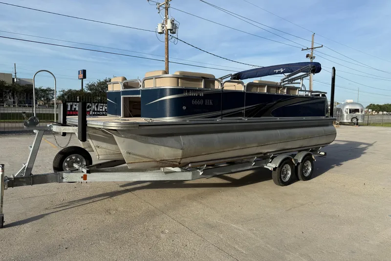 Slide: The Image of 2019 Avalon Venture Fish N Cruise 20' pontoon boat on trailer in parking lot. - 5