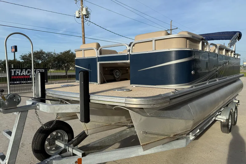 Slide: The Image of 2019 Avalon Venture Fish N Cruise 20' pontoon boat on trailer, parked outdoors. - 6