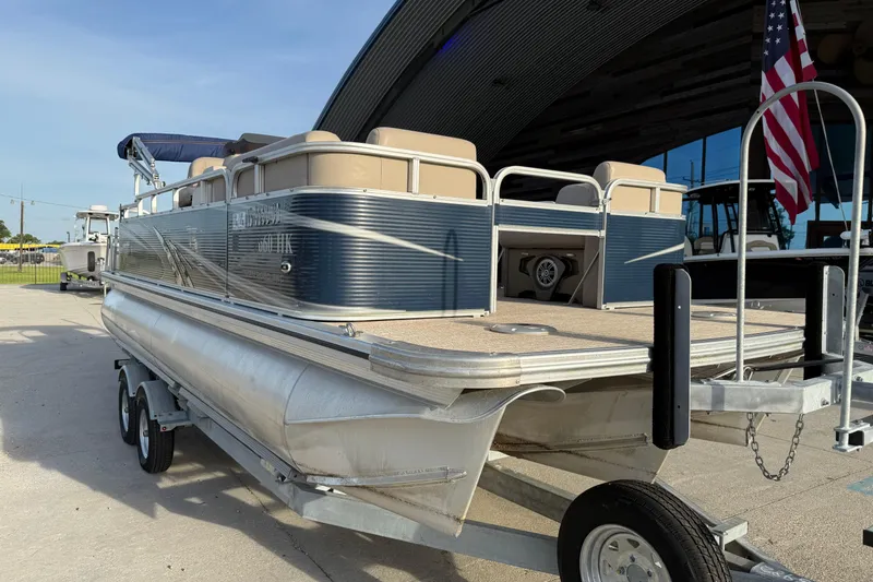 Slide: The Image of 2019 Avalon Venture Fish N Cruise 20' pontoon boat on trailer, parked outdoors. - 7