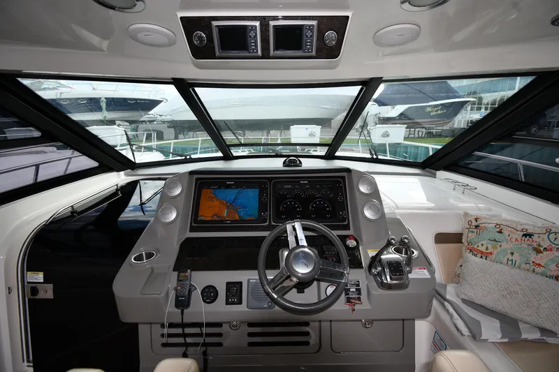 Slide: The Image of 2013 Sea Ray Sundancer 540 helm with navigation screens and steering wheel. - 12