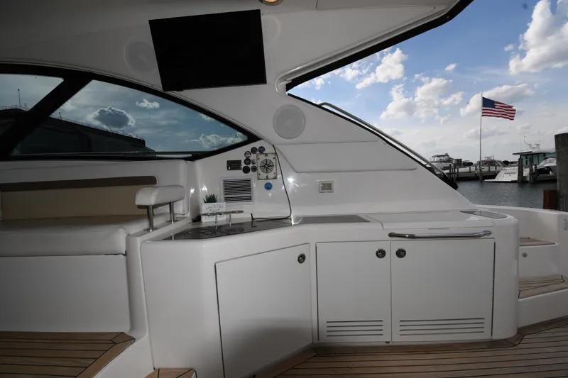 Slide: The Image of 2013 Sea Ray Sundancer 540 yacht interior with kitchenette, seating, and marina view. - 16
