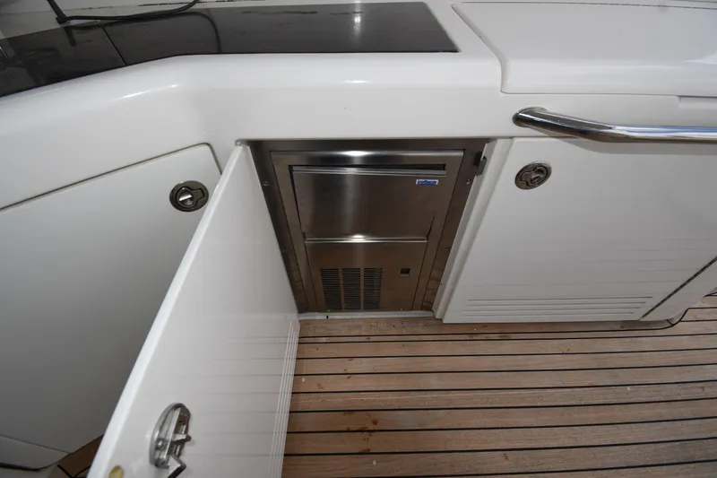 Slide: The Image of 2013 Sea Ray Sundancer 540 yacht interior with open cabinet and stainless steel appliance. - 19