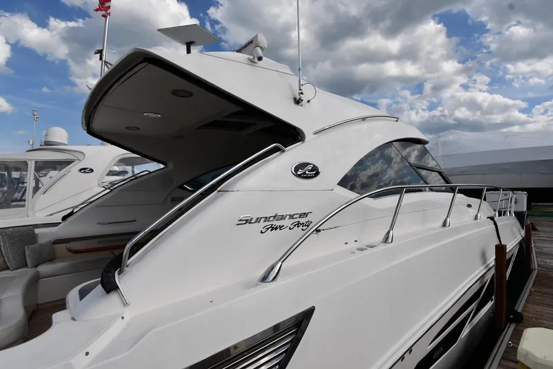 Slide: The Image of 2013 Sea Ray Sundancer 540 yacht docked under a cloudy sky. - 2