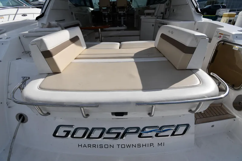Slide: The Image of 2013 Sea Ray Sundancer 540 yacht with cushioned seating, named "Godspeed," docked in Harrison Township, MI. - 23