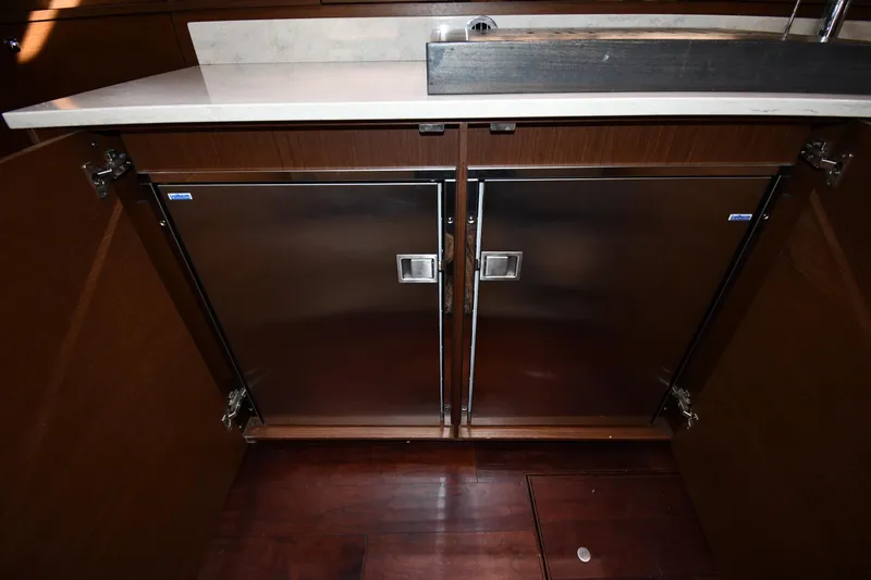 Slide: The Image of 2013 Sea Ray Sundancer 540 galley with stainless steel fridge and wooden cabinetry. - 42
