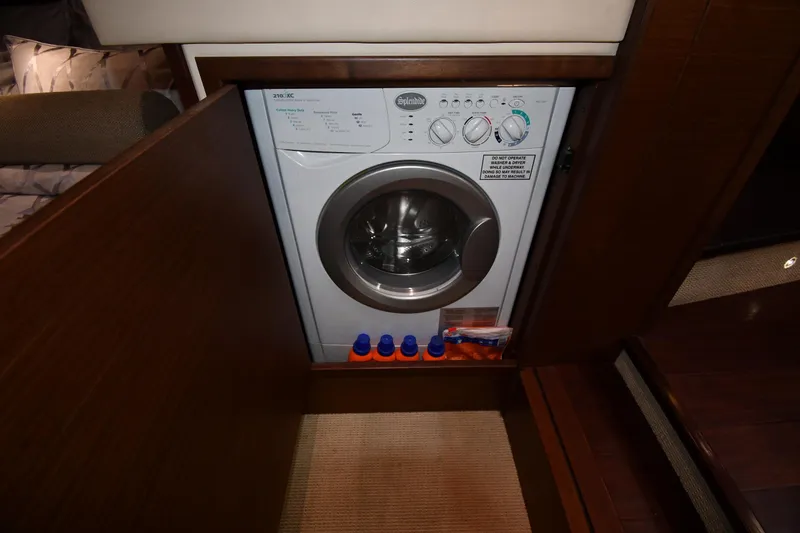 Slide: The Image of 2013 Sea Ray Sundancer 540 interior with built-in washing machine and detergent storage. - 50
