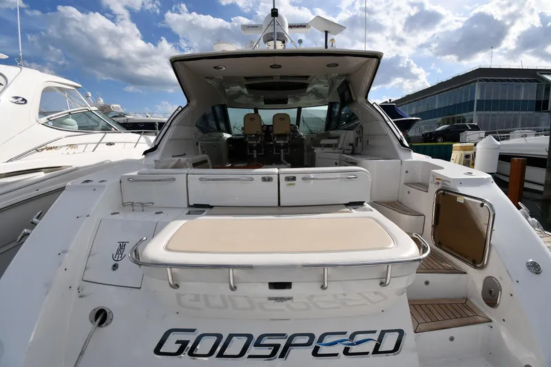 Slide: The Image of 2013 Sea Ray Sundancer 540 yacht docked, featuring spacious deck and luxurious seating. - 7