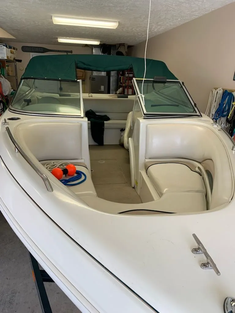 Slide: The Image of 2001 Caravelle Open Bow boat in garage with green canopy. - 2