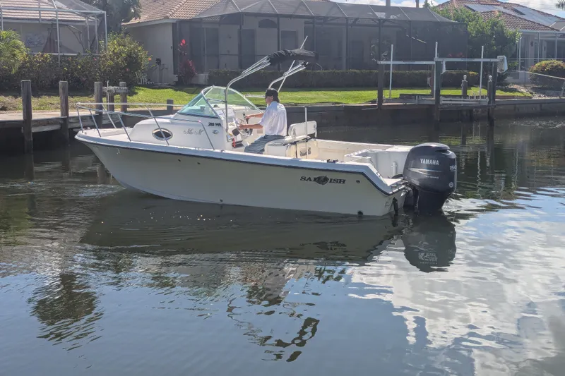 Slide: The Image of 2005 Sailfish 218 WAC boat with Yamaha motor on calm water near docks. - 3