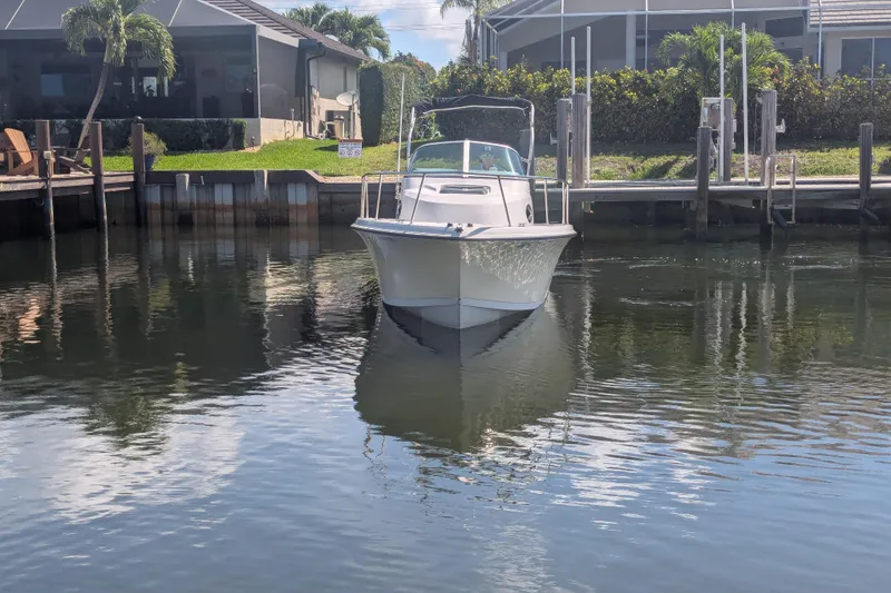 Slide: The Image of 2005 Sailfish 218 WAC boat docked in a calm residential canal. - 6