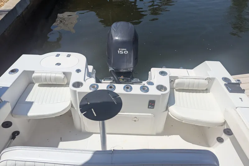Slide: The Image of 2005 Sailfish 218 WAC boat with Yamaha 150 engine, docked in calm waters. - 8