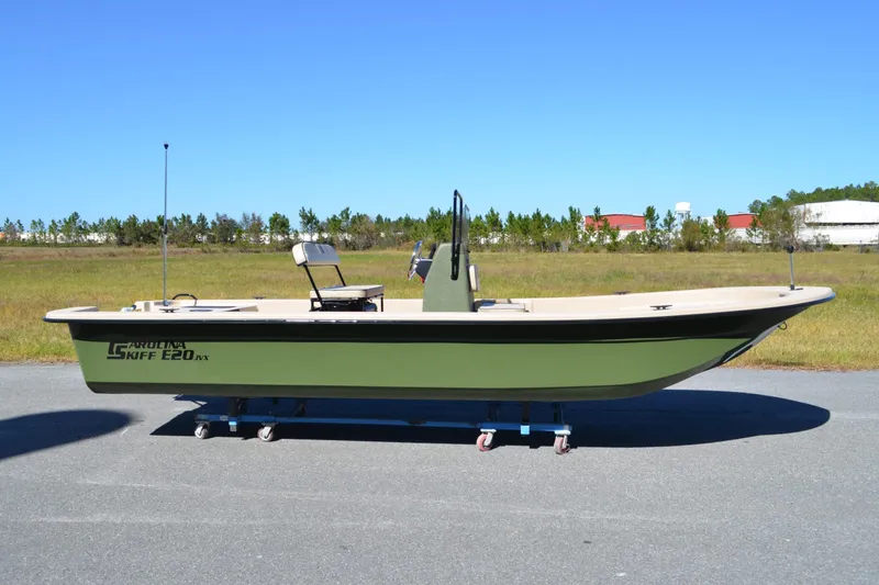 The Image of 2026 Carolina Skiff E20 JVX CC boat on display outdoors, green hull, clear sky background. - 1