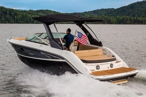 Slide: The Image of Manufacturer Provided Image: 2019 Sea Ray SLX 250 boat cruising on a lake with an American flag. - 4